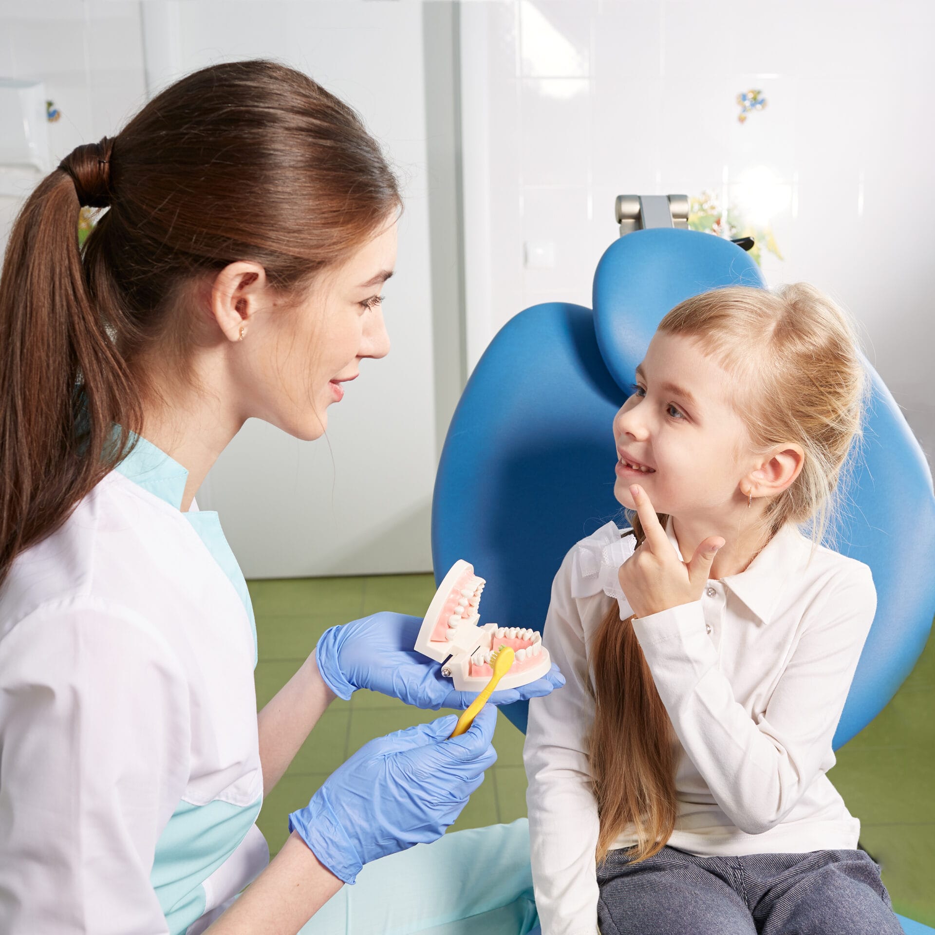 The doctor shows the child the techniques of proper tooth cleaning
