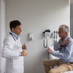 Latin American senior man vising the doctor to check a pain in his shoulder - healthcare and medicine concepts