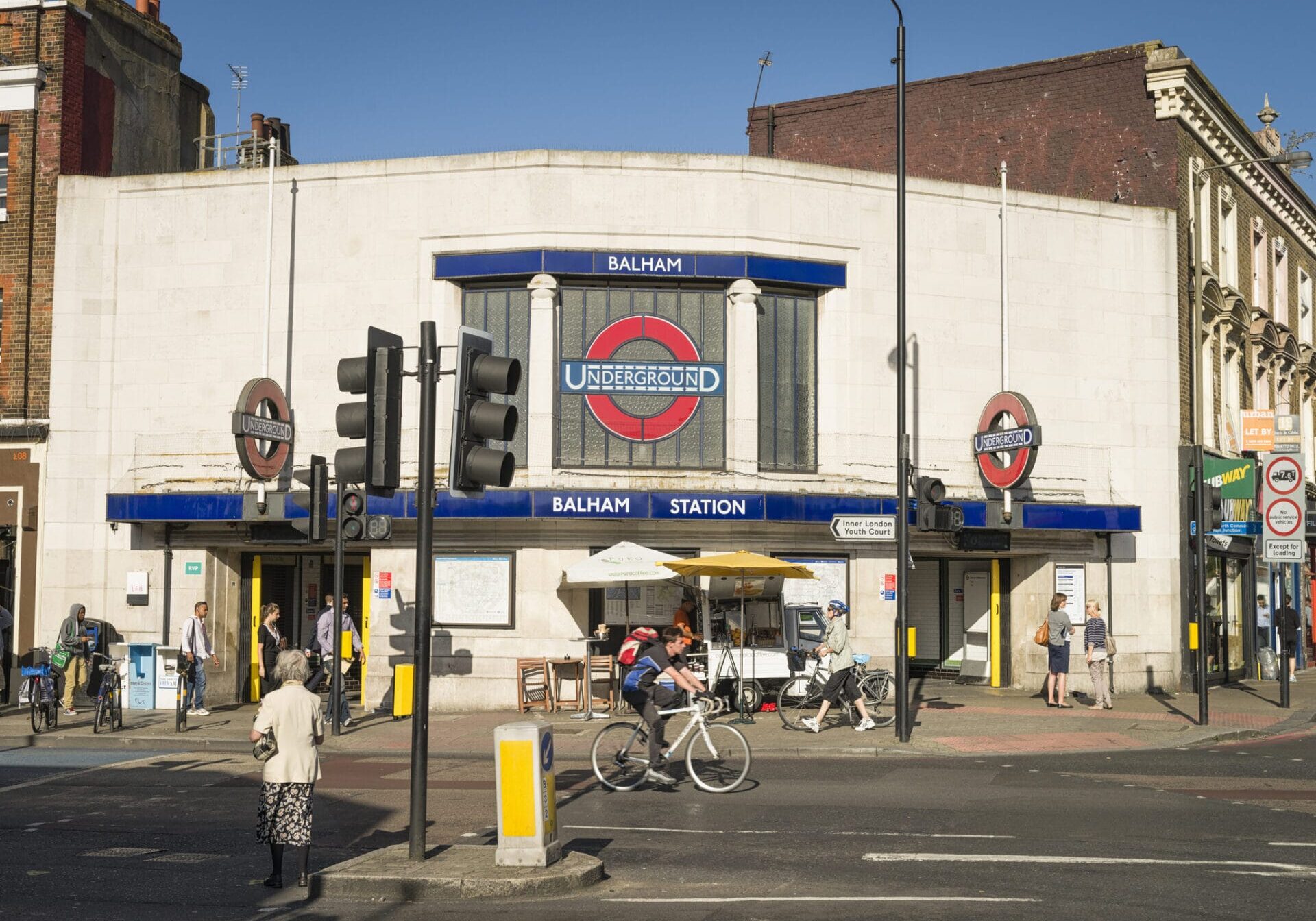 London, UK - September 5, 2012: People on the street and pavement in front of entrances to Balham Underground Station in South West London.