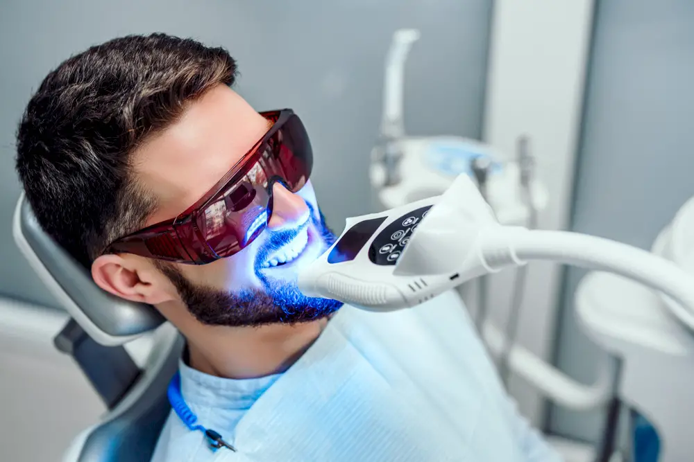 A man getting his teeth whitened in a dentist’s office